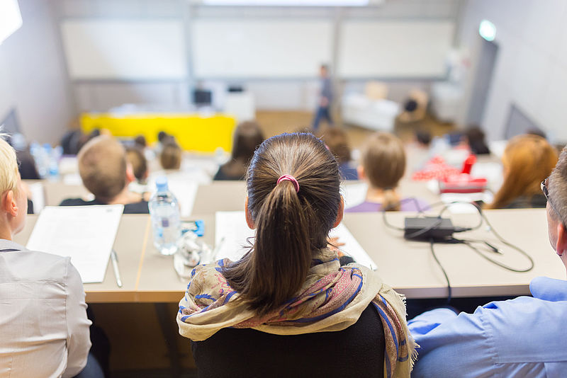 Viele junge Menschen sitzen in einem Hörsaal
